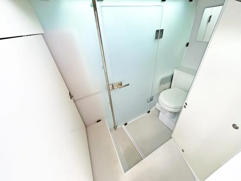 Slide: The Image of 2024 Axopar 37 Sun Top bathroom with modern design and frosted glass door. - 8