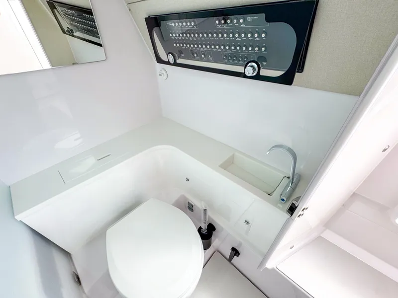 Slide: The Image of 2024 Axopar 37 Sun Top bathroom with modern fixtures and control panel. - 9