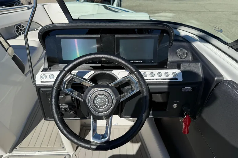 Slide: The Image of 2023 Crownline 240 SS SURF boat dashboard with steering wheel and dual displays. - 12