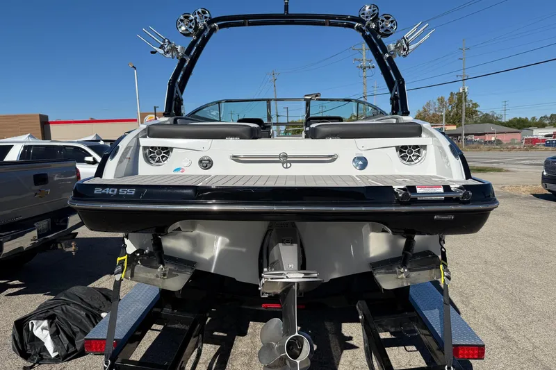 Slide: The Image of 2023 Crownline 240 SS SURF boat on trailer, rear view, showcasing sleek design and features. - 17