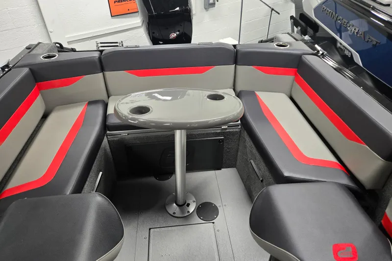 Slide: The Image of 2026 Princecraft Sport 175 boat interior with gray and red seating and a central table. - 16