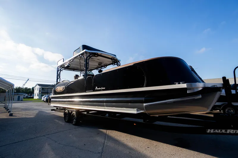 Slide: The Image of 2026 Aloha Paradise 300 Sundeck boat on trailer under clear blue sky. - 11