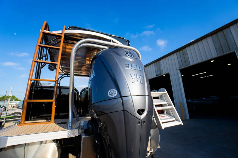 Slide: The Image of 2026 Aloha Paradise 300 Sundeck with powerful 350 V6 engine, docked near a warehouse. - 13