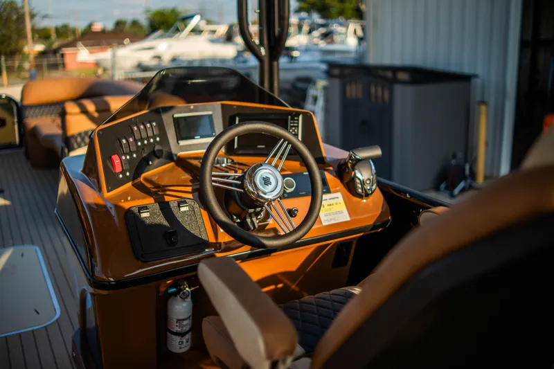 Slide: The Image of 2026 Aloha Paradise 300 Sundeck boat dashboard with steering wheel and controls. - 4