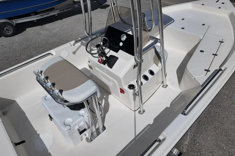 Slide: The Image of 2026 Bulls Bay 2200 boat interior with steering console and seating, parked on gravel. - 11