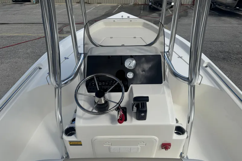 Slide: The Image of 2025 Bulls Bay 2200 boat console with steering wheel and gauges, docked outdoors. - 12