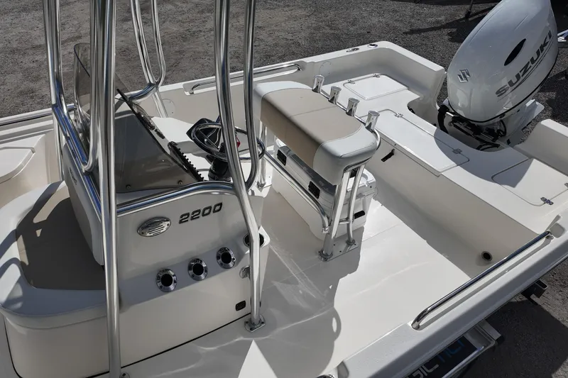 Slide: The Image of 2026 Bulls Bay 2200 boat interior with Suzuki engine, featuring steering console and seating. - 18
