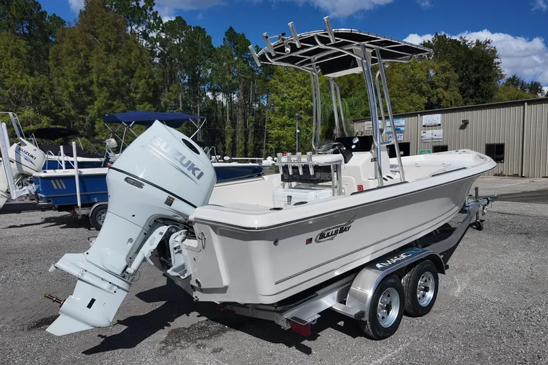 Slide: The Image of 2026 Bulls Bay 2200 boat with Suzuki outboard motor on a trailer, parked outdoors. - 7
