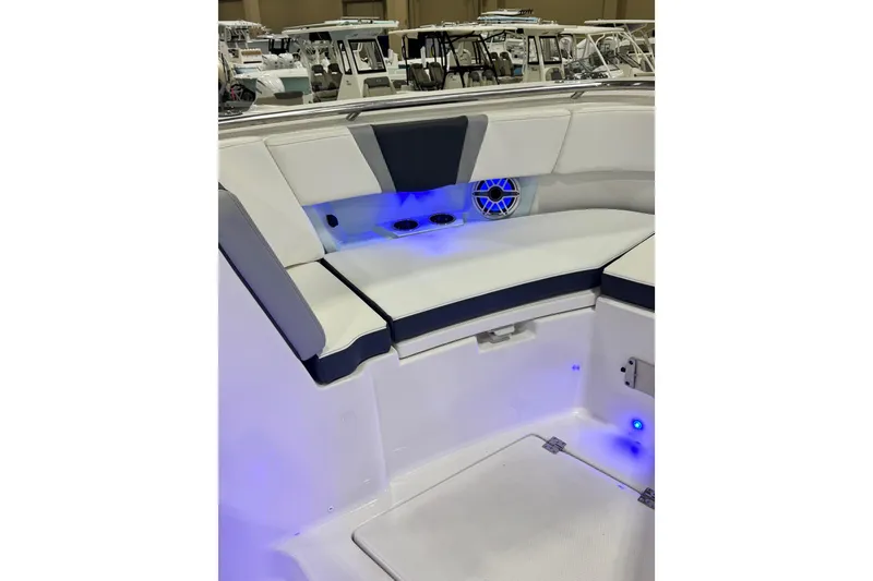 Slide: The Image of 2026 Robalo R360 Center Console boat interior with blue LED lighting and cushioned seating. - 30