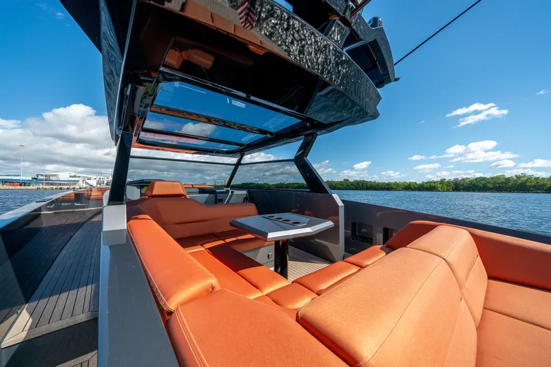 Slide: The Image of 2022 Vanquish Yachts VQ45 with orange seating, sleek design, and open water view. - 10