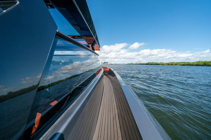 Slide: The Image of 2022 Vanquish Yachts VQ45 cruising on a sunny day, reflecting blue skies and water. - 22