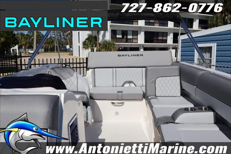 Slide: The Image of 2026 Bayliner D20 boat interior with gray seating, cup holders, and branding. - 26