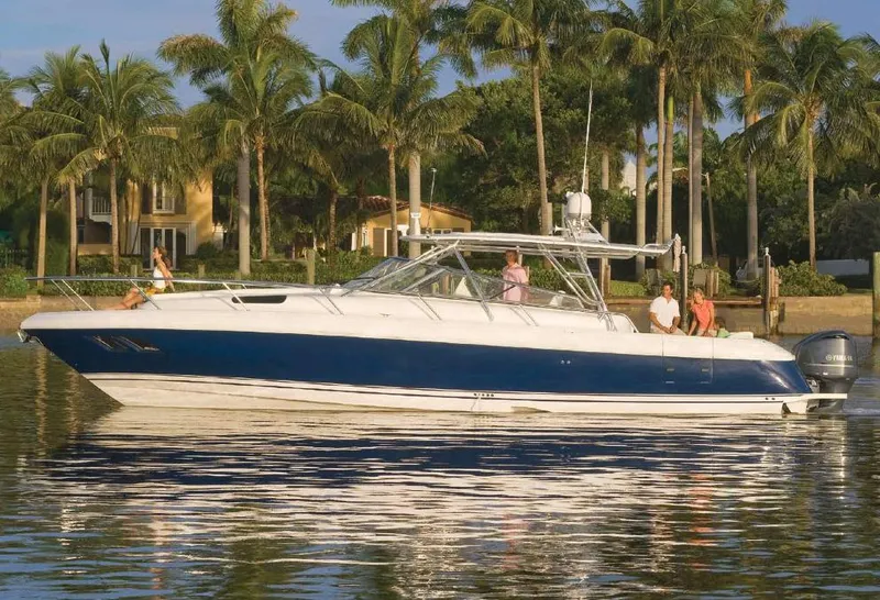 Slide: The Image of Manufacturer Provided Image: 2014 Intrepid 430 Sport Yacht cruising on a calm waterway with palm trees in the background. - 1