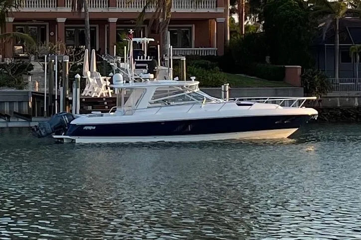 Slide: The Image of 2012 Intrepid 430 Sport Yacht docked by waterfront home. - 2