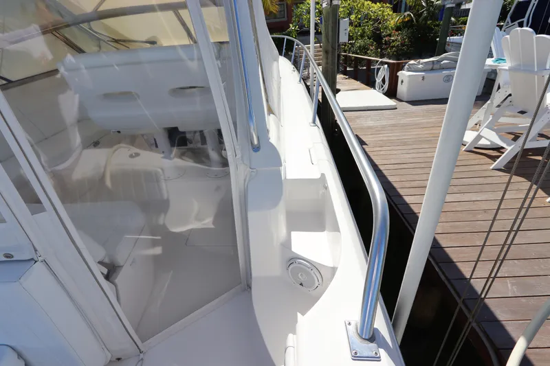 Slide: The Image of 2012 Intrepid 430 Sport Yacht docked, showcasing sleek white interior and polished railings. - 25