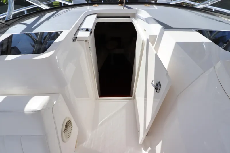 Slide: The Image of 2012 Intrepid 430 Sport Yacht cabin entrance with open door, showcasing sleek white interior. - 43