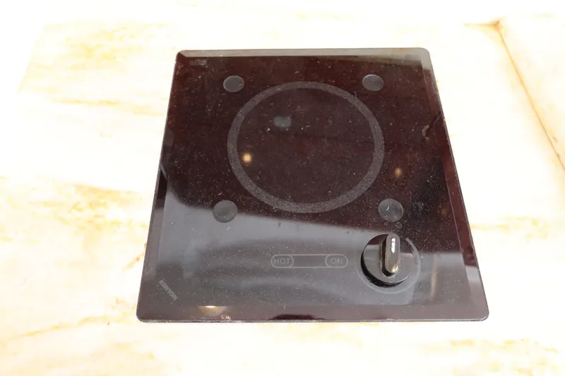 Slide: The Image of Electric stovetop on a 2012 Intrepid 430 Sport Yacht, featuring a single burner and control knob. - 49