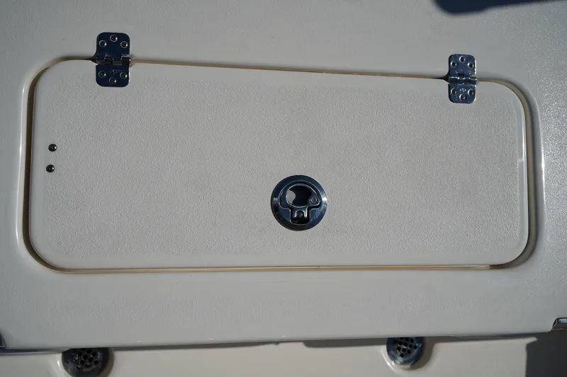 Slide: The Image of 2024 Key West 210 Bay Reef boat compartment with metal hinges and latch. - 16