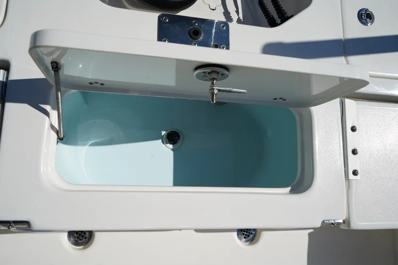 Slide: The Image of 2024 Key West 210 Bay Reef boat livewell with open lid, showcasing interior design. - 17
