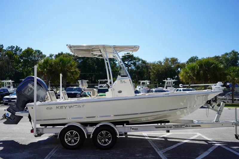 Slide: The Image of 2024 Key West 210 Bay Reef boat on trailer, parked outdoors. - 2