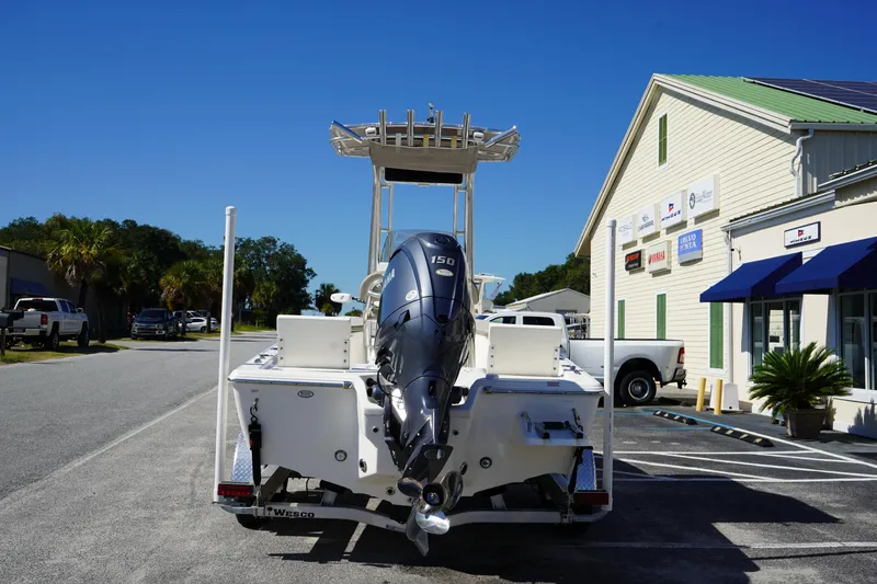 Slide: The Image of 2024 Key West 210 Bay Reef boat with Yamaha engine, parked outside a marine dealership. - 6