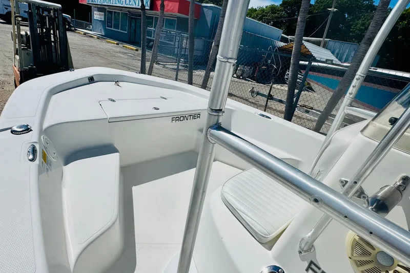 Slide: The Image of 2014 Frontier 180 boat interior at a marina, showcasing seating and storage. - 6