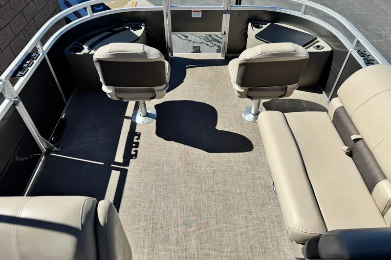 Slide: The Image of 2024 Sun Tracker Fishin' Barge 20 DLX interior with beige seating and fishing chairs. - 10