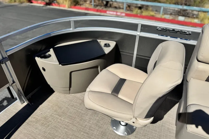 Slide: The Image of 2024 Sun Tracker Fishin' Barge 20 DLX interior with beige seating and console. - 13