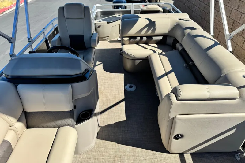 Slide: The Image of 2024 Sun Tracker Fishin' Barge 20 DLX interior with plush seating and steering console. - 17