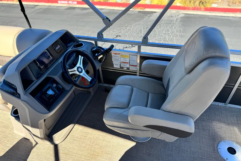 Slide: The Image of 2024 Sun Tracker Fishin' Barge 20 DLX helm with steering wheel and captain's chair. - 24