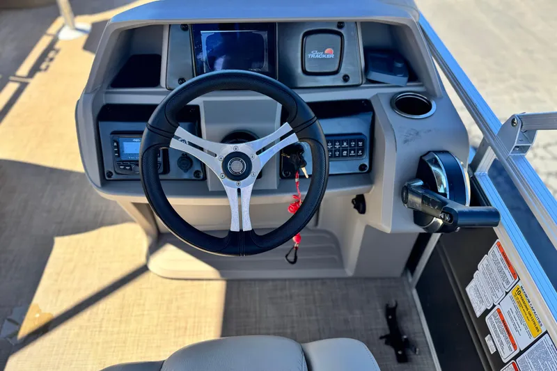 Slide: The Image of 2024 Sun Tracker Fishin' Barge 20 DLX steering console with controls and dashboard. - 25