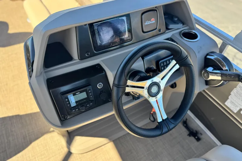Slide: The Image of 2024 Sun Tracker Fishin' Barge 20 DLX dashboard with steering wheel and controls. - 26
