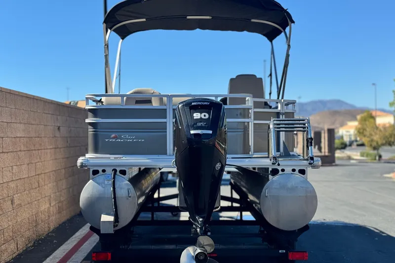 Slide: The Image of 2024 Sun Tracker Fishin' Barge 20 DLX pontoon boat with Mercury 90 engine, parked outdoors. - 5