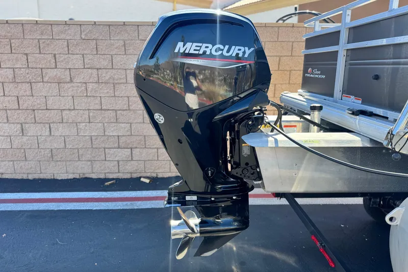 Slide: The Image of 2024 Sun Tracker Fishin' Barge 20 DLX with Mercury outboard motor, parked outdoors. - 7