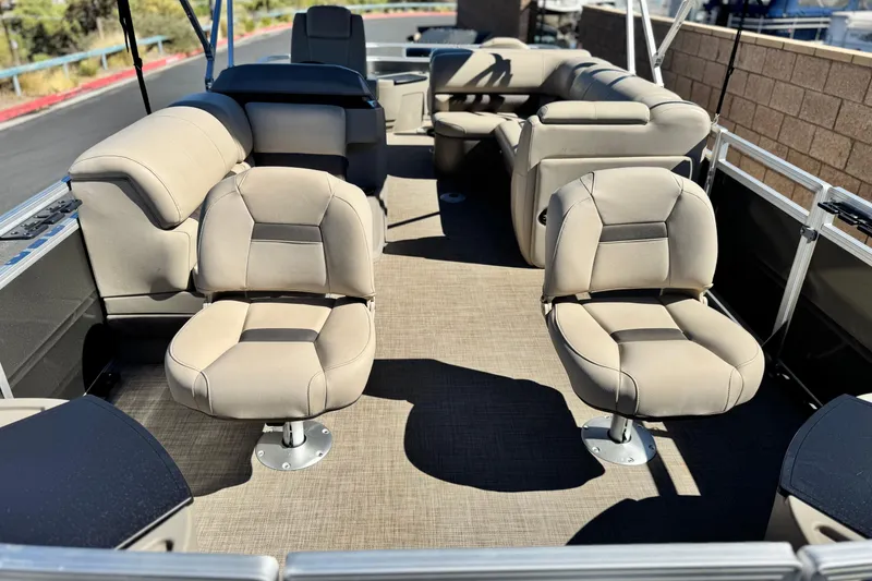 Slide: The Image of 2024 Sun Tracker Fishin' Barge 20 DLX interior with beige seating and spacious layout. - 9