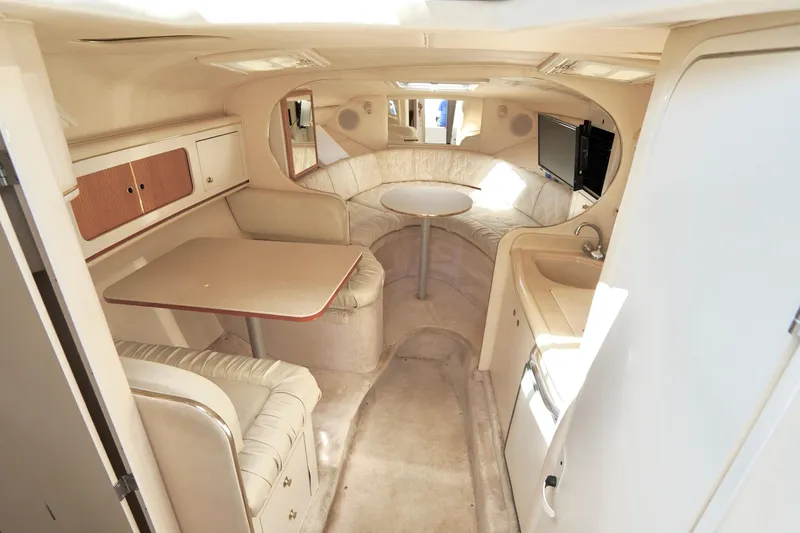 Slide: The Image of Interior of 2000 Sea Ray 280 Sundancer boat with seating, table, and kitchenette. - 12