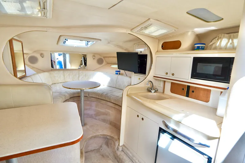 Slide: The Image of Interior of 2000 Sea Ray 280 Sundancer with kitchenette, seating, and modern amenities. - 13