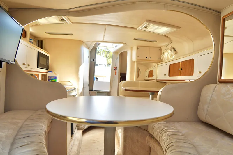 Slide: The Image of Interior of 2000 Sea Ray 280 Sundancer with cozy dining area and storage cabinets. - 18