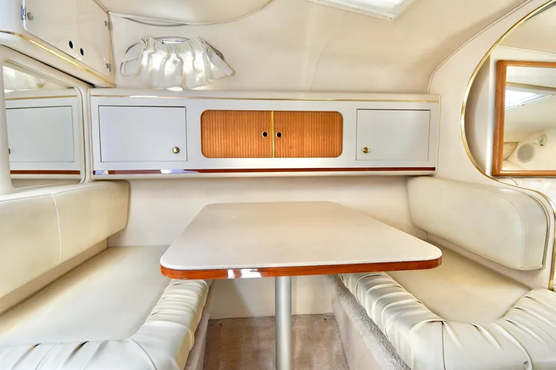 Slide: The Image of Interior of 2000 Sea Ray 280 Sundancer boat, featuring cozy seating and storage cabinets. - 19