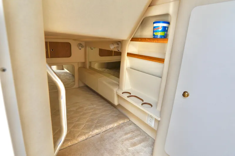 Slide: The Image of Interior cabin of 2000 Sea Ray 280 Sundancer with cozy sleeping area and storage shelves. - 21