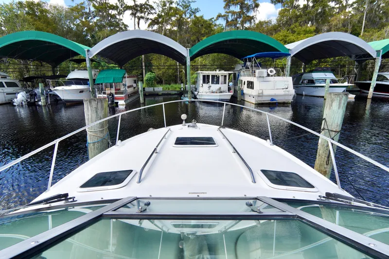 Slide: The Image of Bow view of a 2000 Sea Ray 280 Sundancer docked at a marina with covered slips. - 4