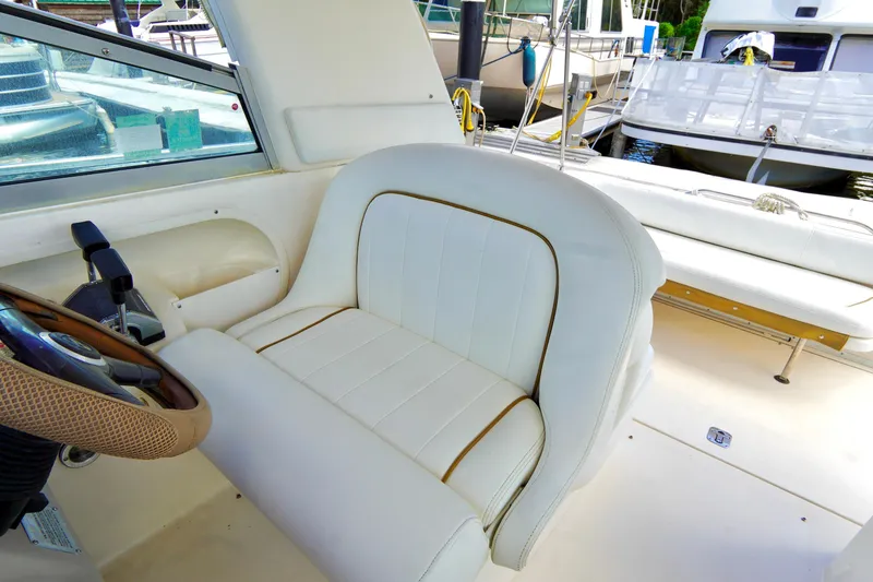 Slide: The Image of Interior of 2000 Sea Ray 280 Sundancer boat with white seating and steering wheel. - 7