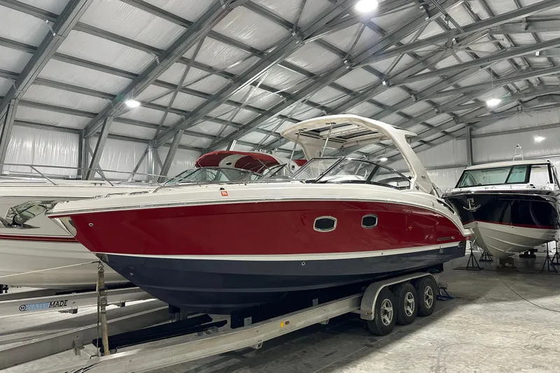 Slide: The Image of 2021 Chaparral 347 SSX boat in storage, red and white exterior, on a trailer. - 10