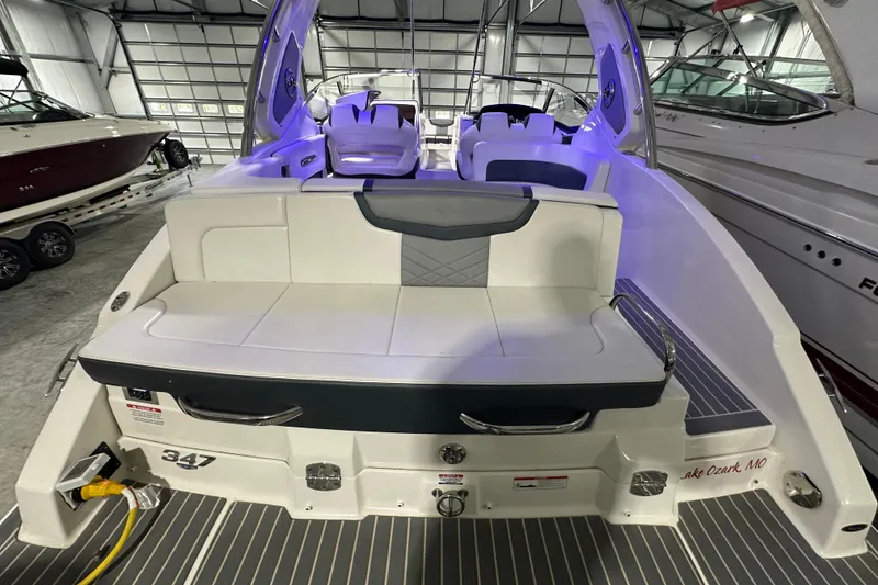 Slide: The Image of 2021 Chaparral 347 SSX boat interior with seating, illuminated in a showroom. - 15