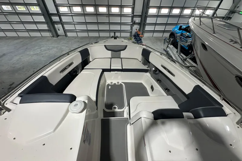 Slide: The Image of 2021 Chaparral 347 SSX boat interior with spacious seating in a garage setting. - 25