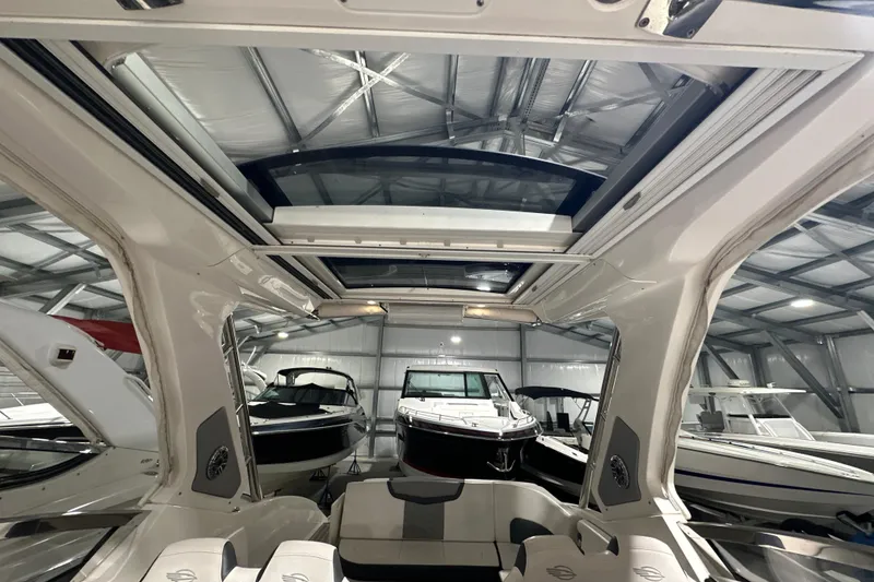 Slide: The Image of 2021 Chaparral 347 SSX boat interior with open sunroof in a storage facility. - 44