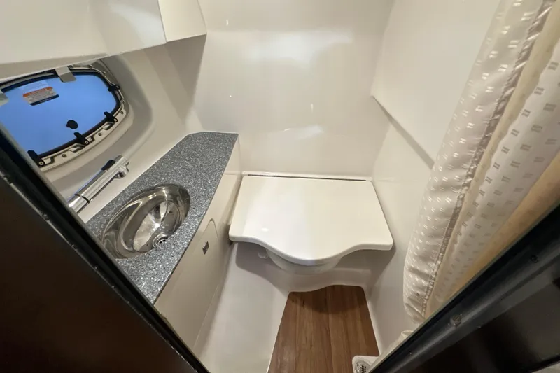 Slide: The Image of 2021 Chaparral 347 SSX boat bathroom with sink, toilet, and window. - 48