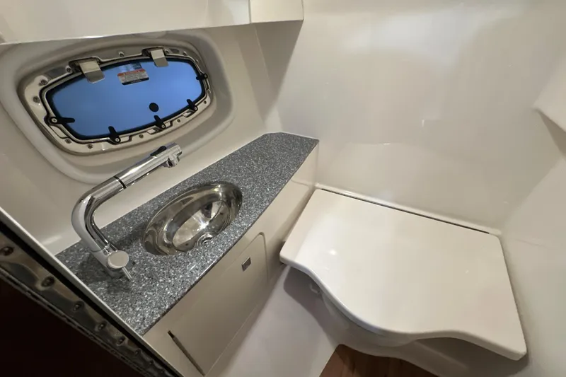 Slide: The Image of 2021 Chaparral 347 SSX boat bathroom with sink, faucet, and porthole window. - 49