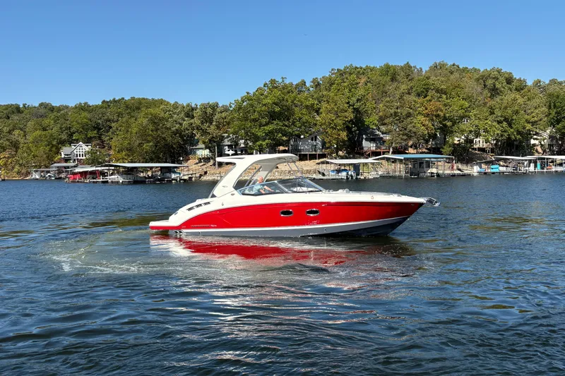 Slide: The Image of 2021 Chaparral 347 SSX boat cruising on a scenic lake with forested shoreline. - 5