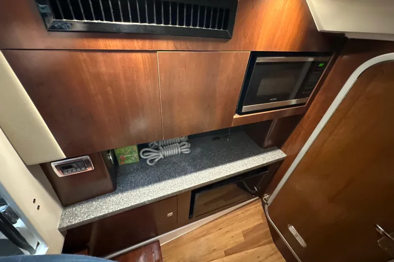 Slide: The Image of 2021 Chaparral 347 SSX interior kitchen with microwave and wooden cabinetry. - 53